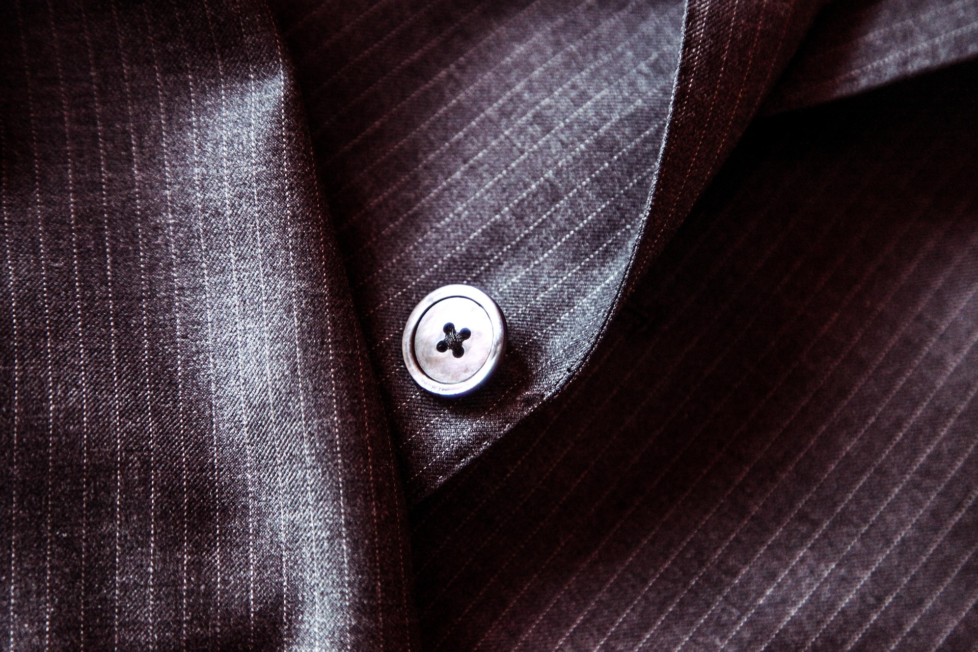 close up of detail of suit, featuring button