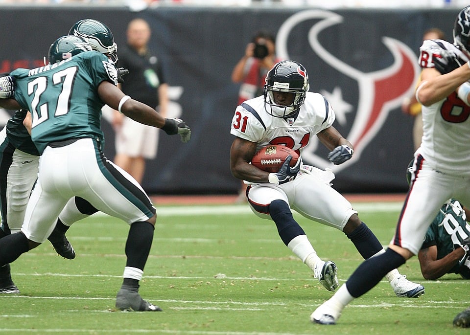 A Houston Texans running back tries to juke a Philadephia Eagles defender during an NFL game.