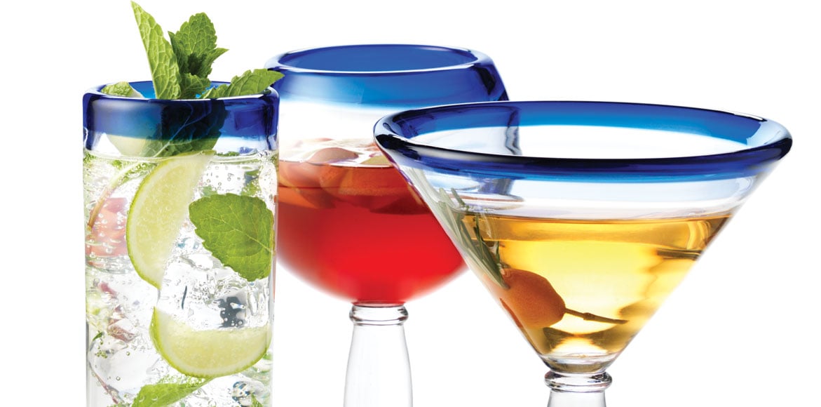 Three glasses, made by Libbey, each with a mixed drink in them. 