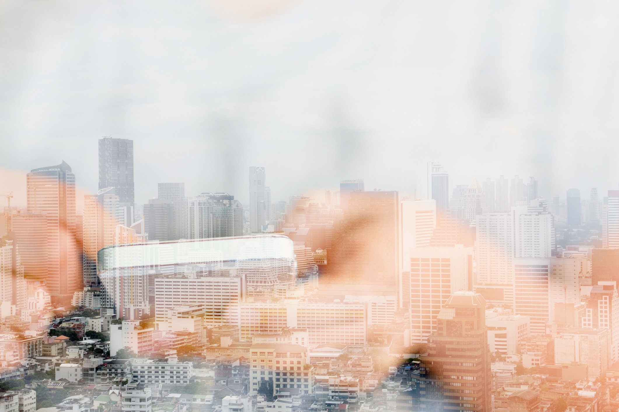 A graphic of hands holding  a cellphone opaque in front of a cityscape.