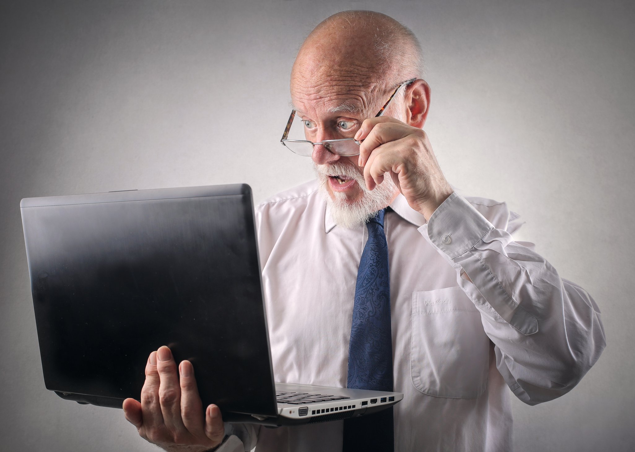 Man looking at a laptop in shock 