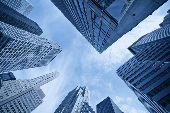 An upward-looking view of skyscrapers against a blue sky.