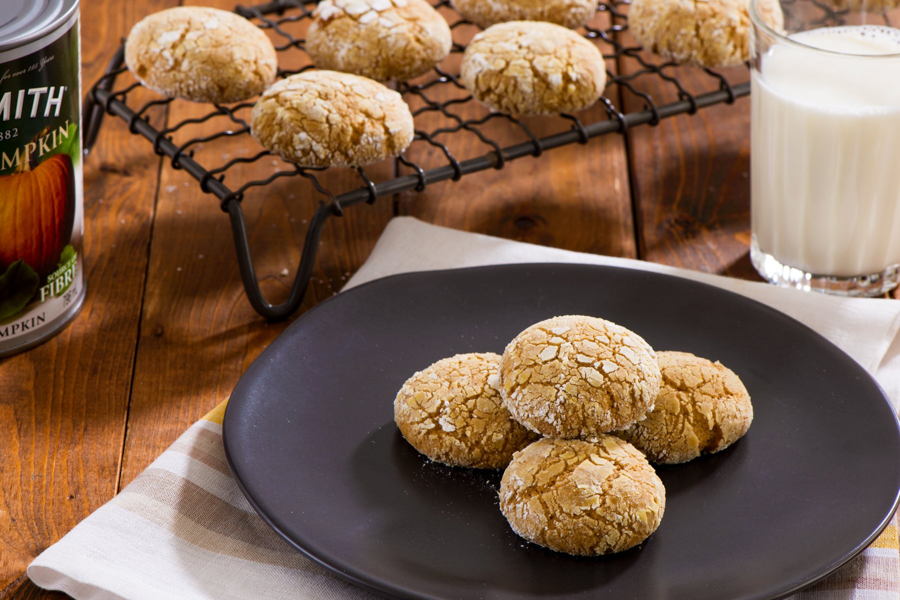 A plate of pumpkin cookies next to a can of processed pumpkin filling.