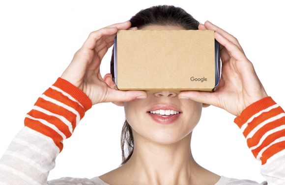 Woman holding a Google Cardboard device to her face.