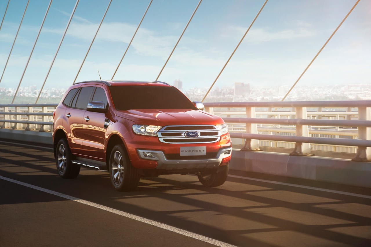 A red Ford Everest driving on a bridge.