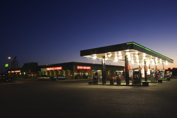 An exterior view of a gas station at night.