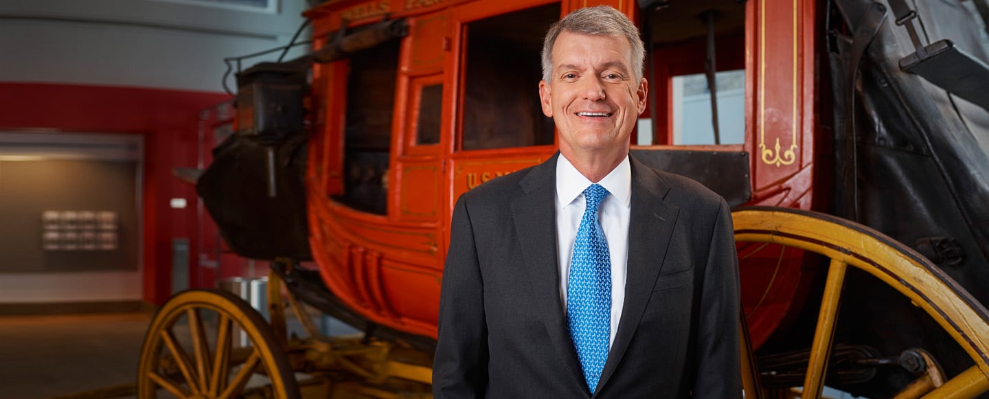 Wells Fargo CEO Tim Sloan in front of a stagecoach.