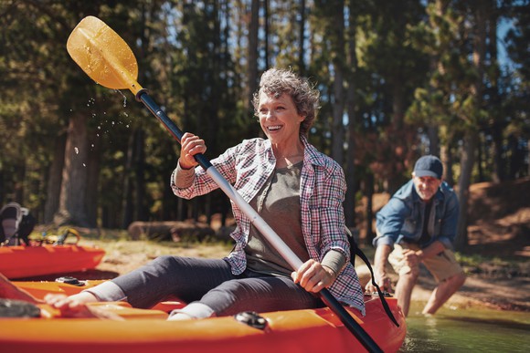 A woman paddle boating with her husband.
