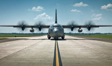 A C-130 airplane on a runway.