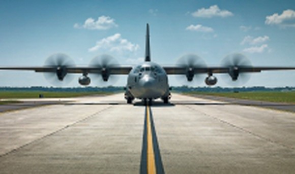 A C-130 airplane on a runway.