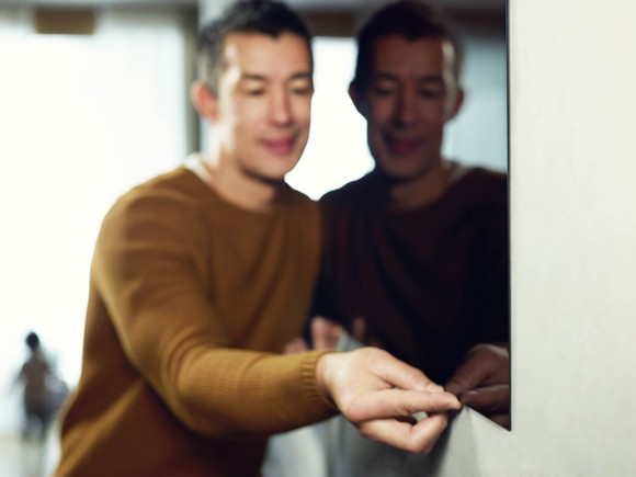 A man puts a thin TV on the wall.
