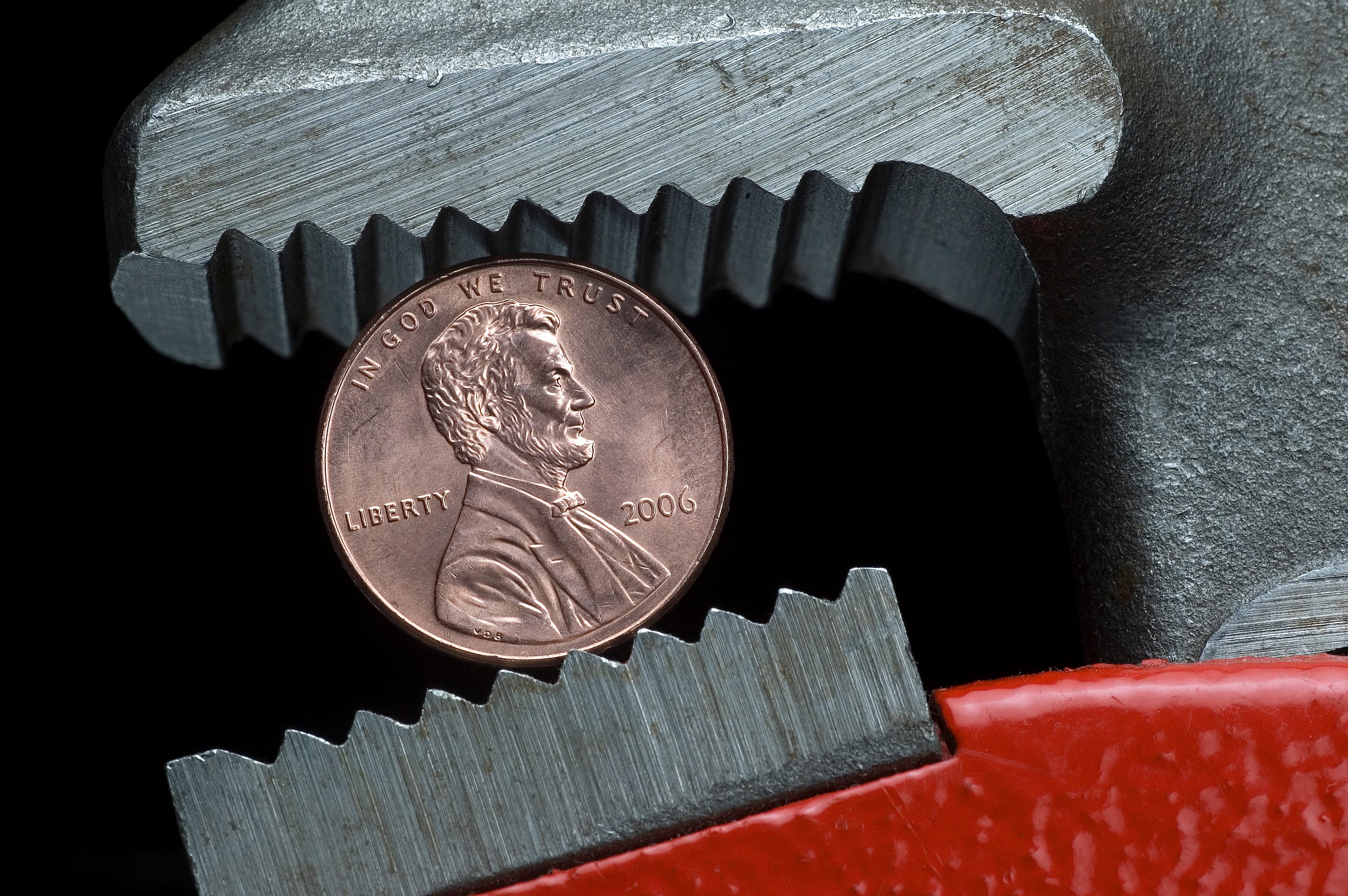 A penny being held in a wrench.