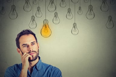Man with light bulb drawings in background