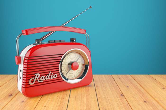 Vintage red radio receiver on a wood table.