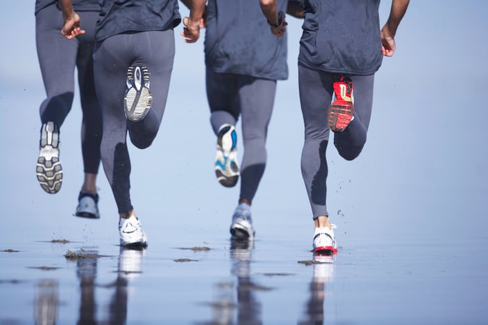 A group of joggers on the beach.