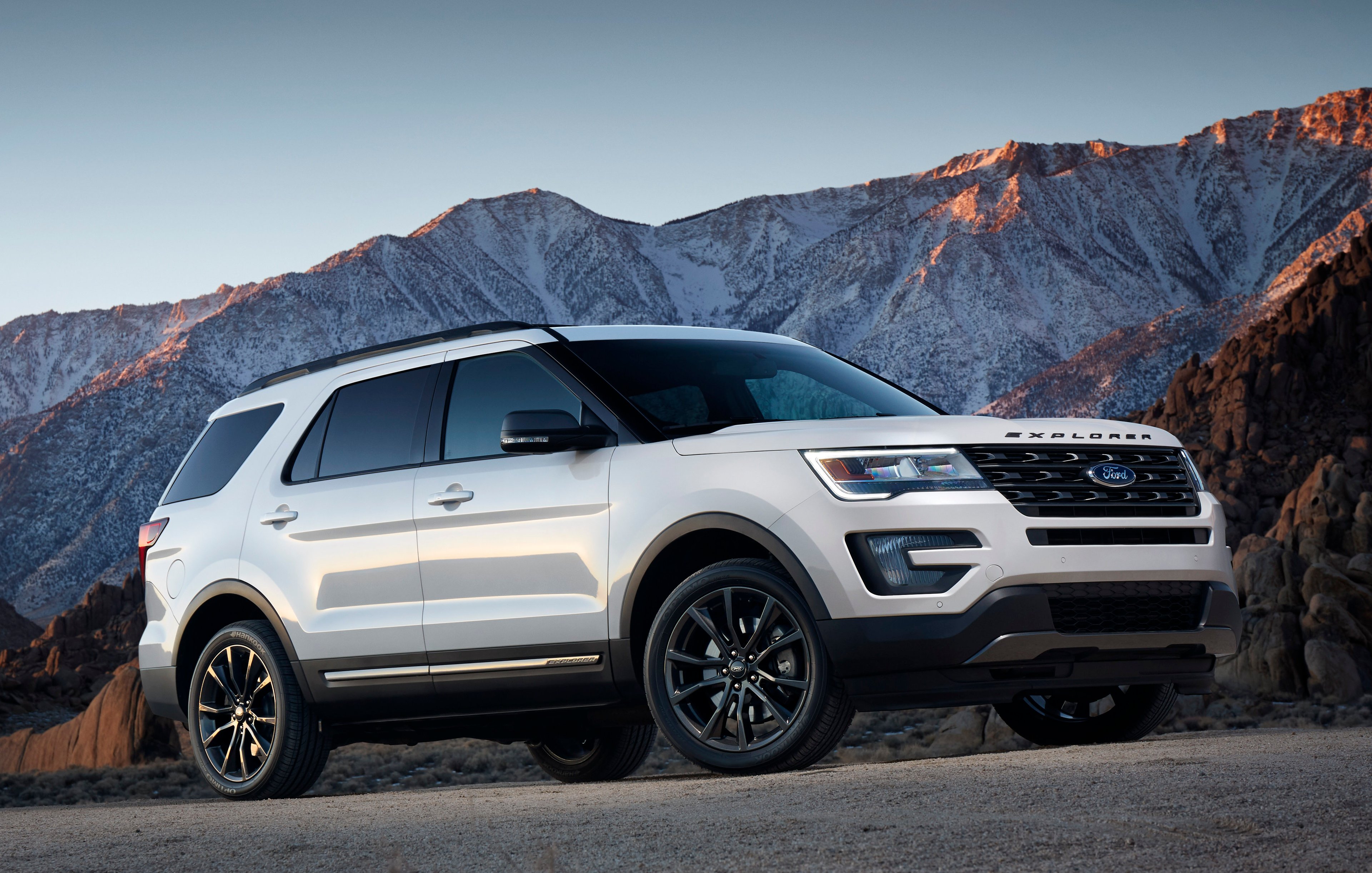 A white Explorer SUV on a hillside