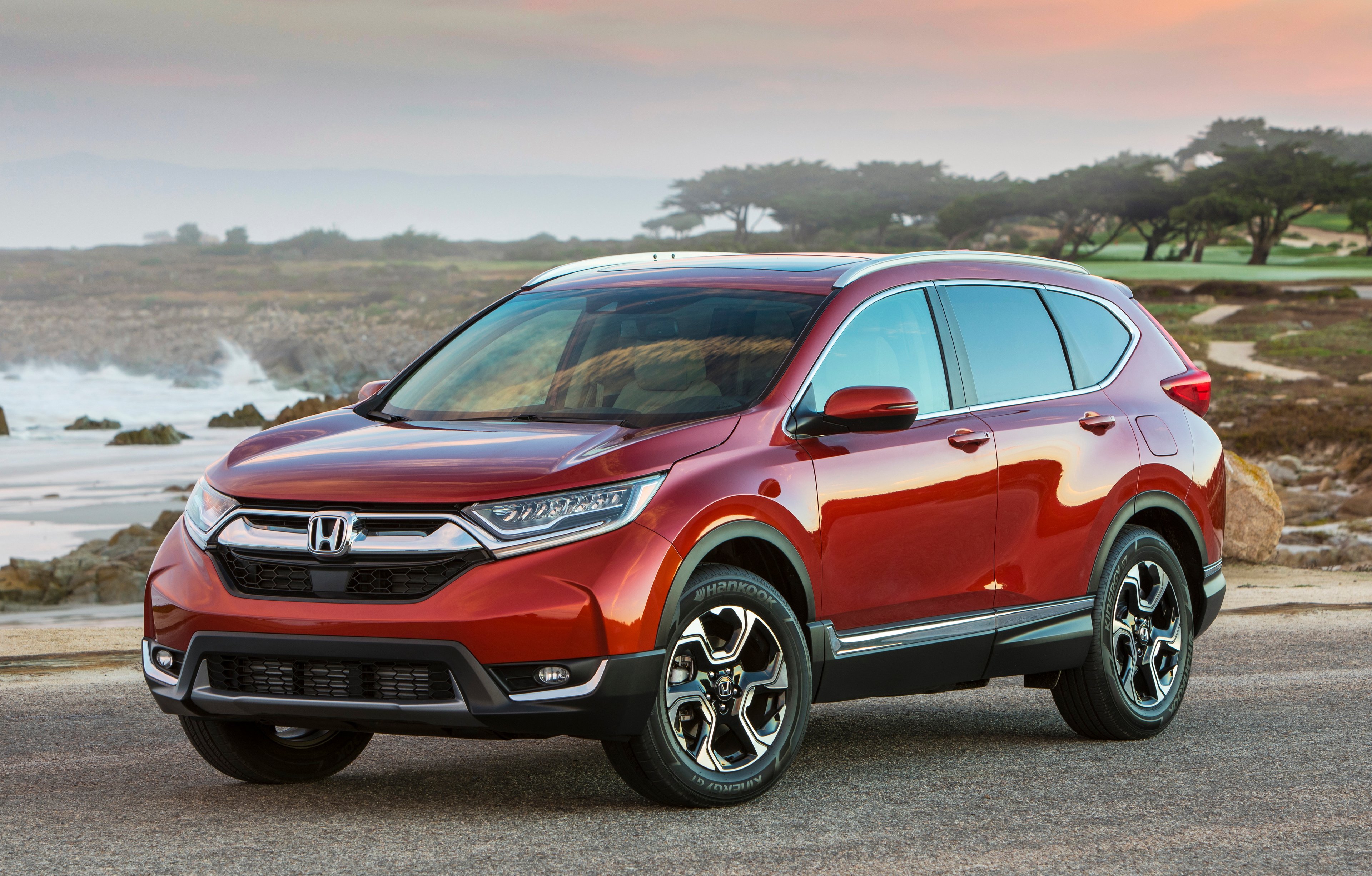 A red Honda CR-V SUV parked near a golf course