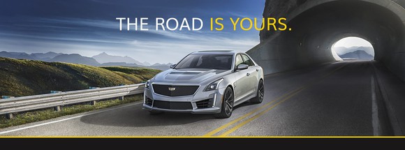 Car driving with text above the car reading, "The road is yours"