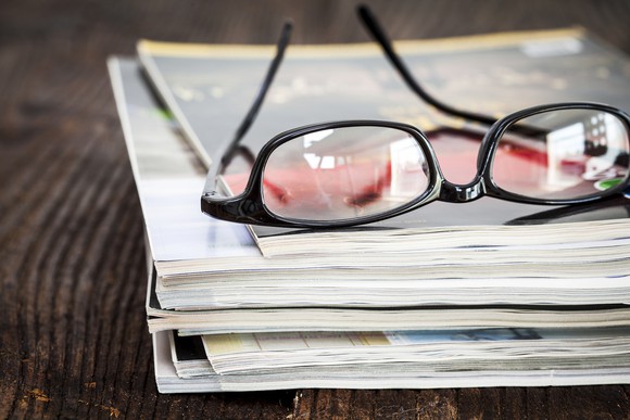 Eyeglasses on top of a stack of magazines