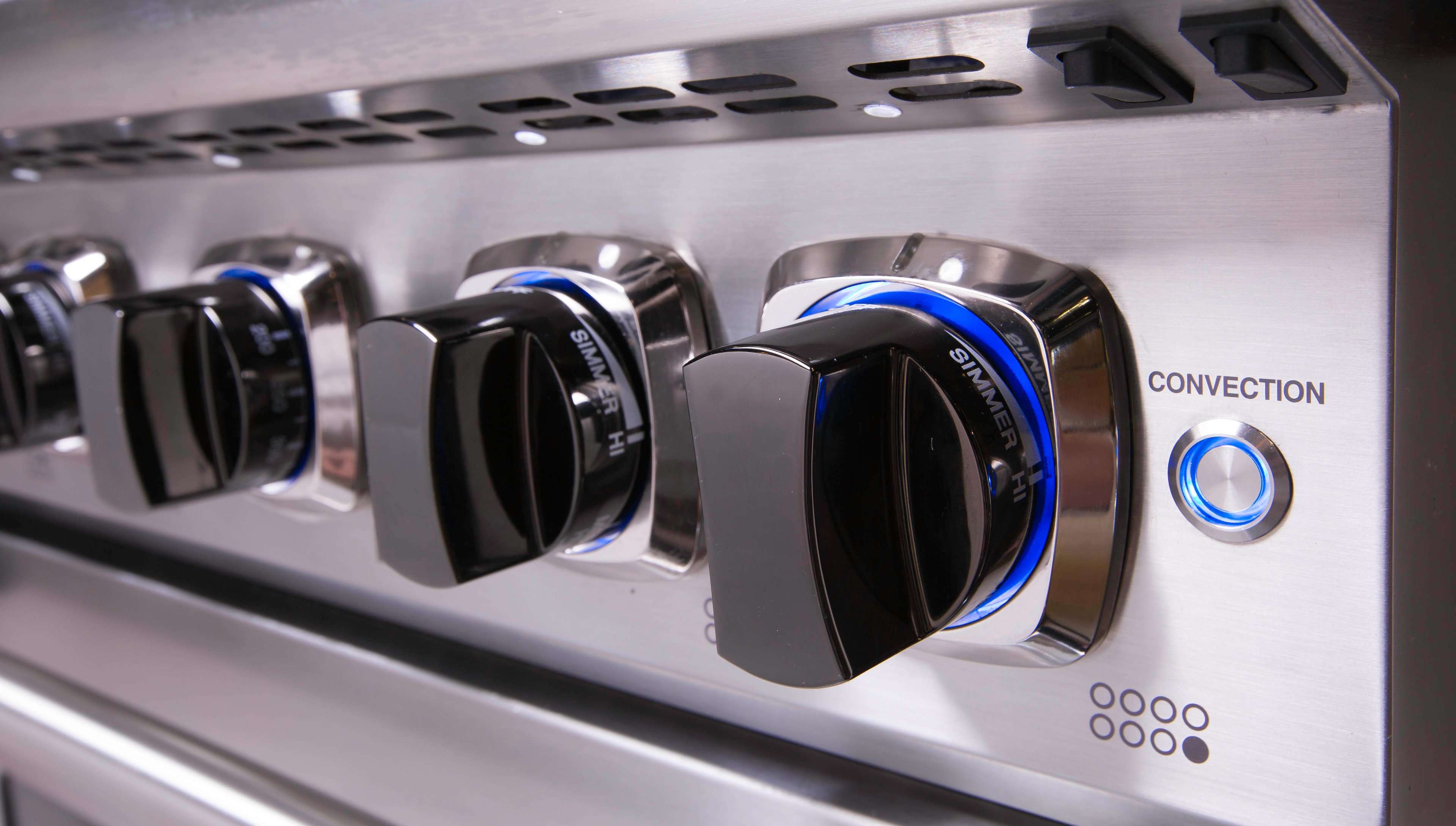 Multiple knobs on a professional stove.