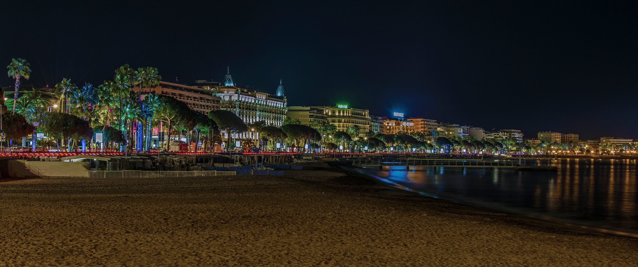 The illuminated city of Cannes, France, from the beach at night.