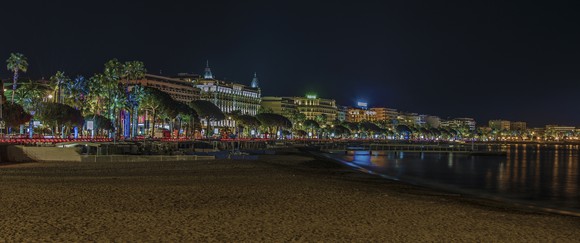 The illuminated city of Cannes, France, from the beach at night.