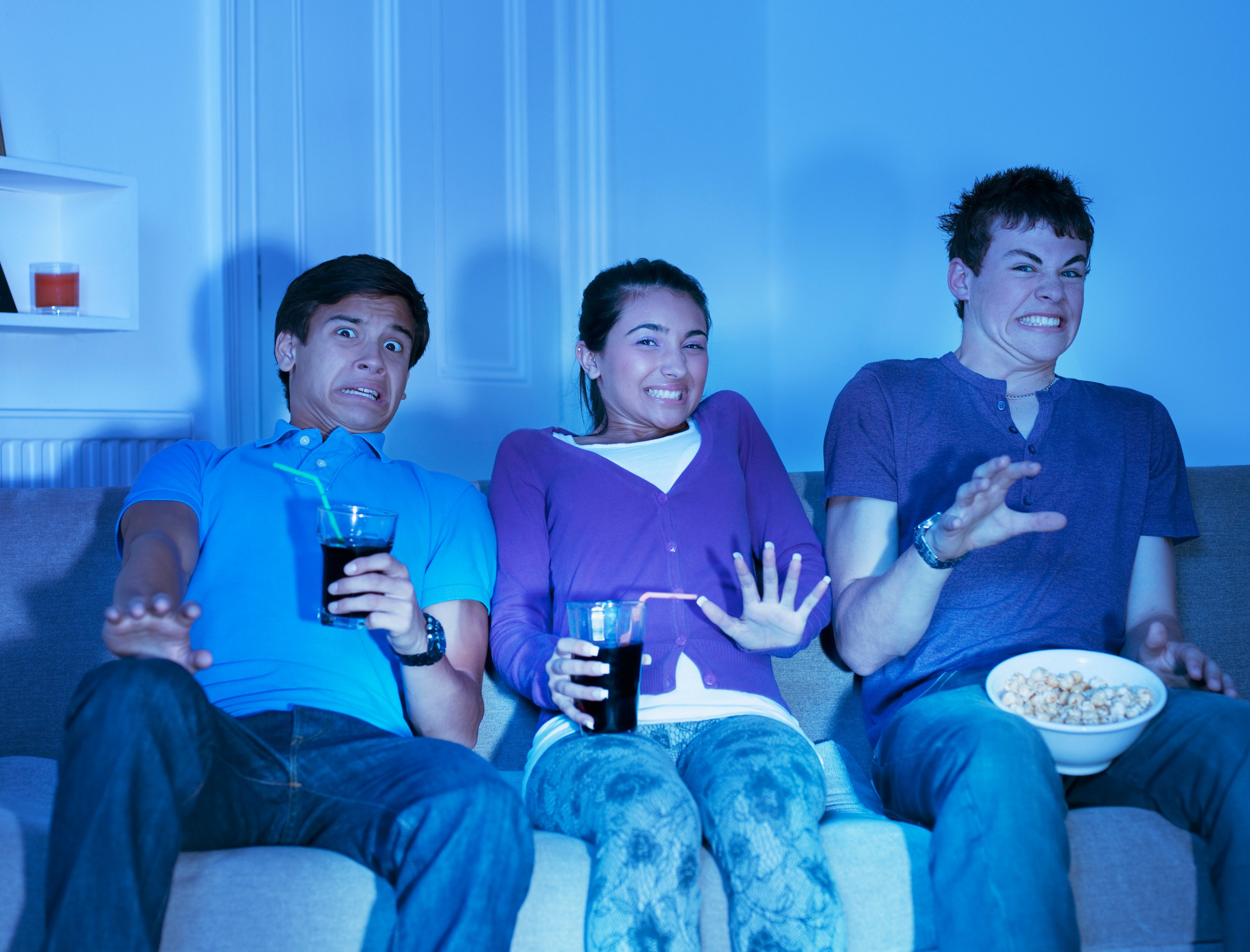 Several teens stream content from the sofa at home.