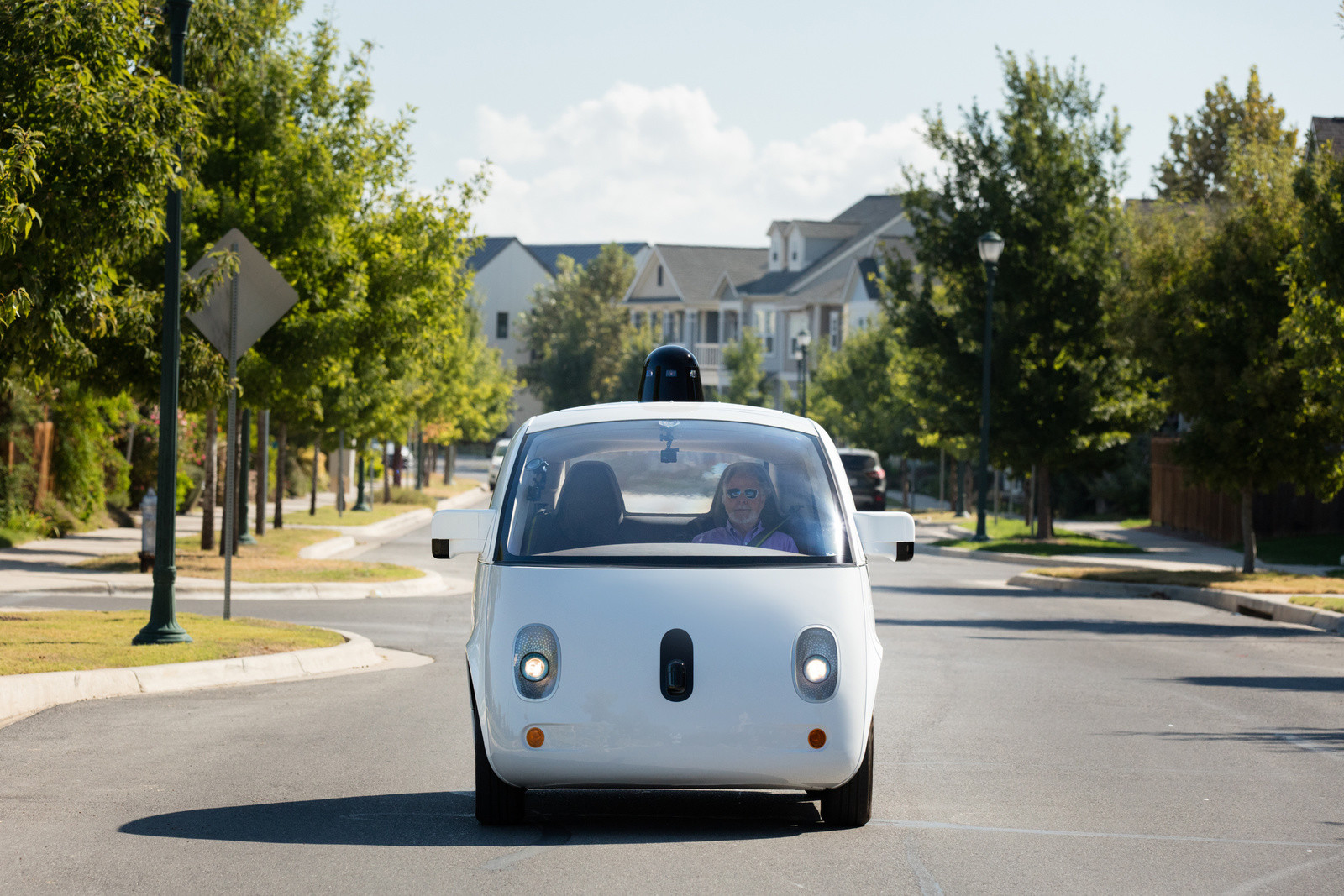 One of Alphabet's Waymo self-driving cars drives down a street.