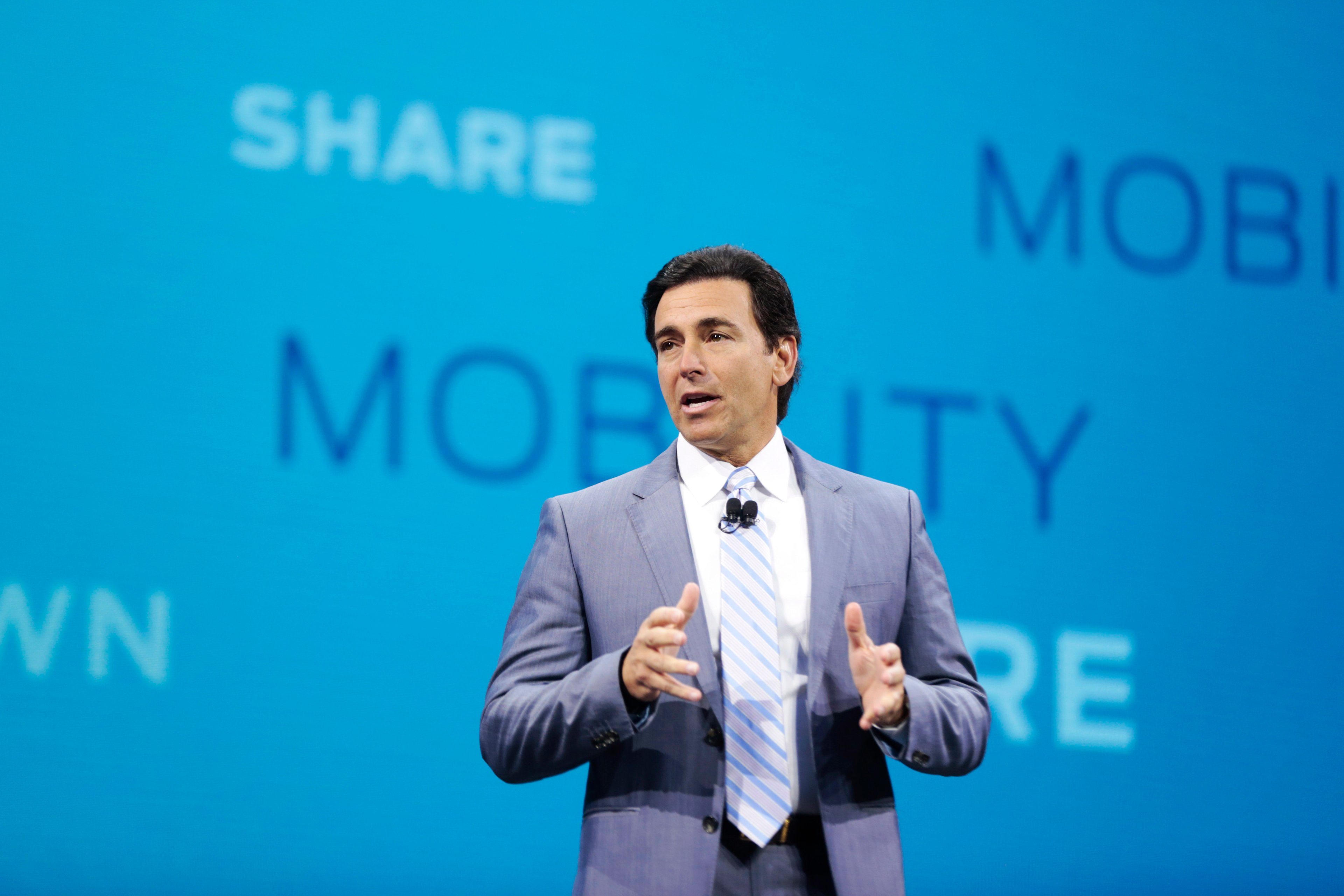 Fields is on stage in front of a backdrop listing mobility-related terms.