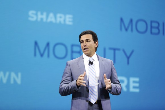 Fields is on stage in front of a backdrop listing mobility-related terms.