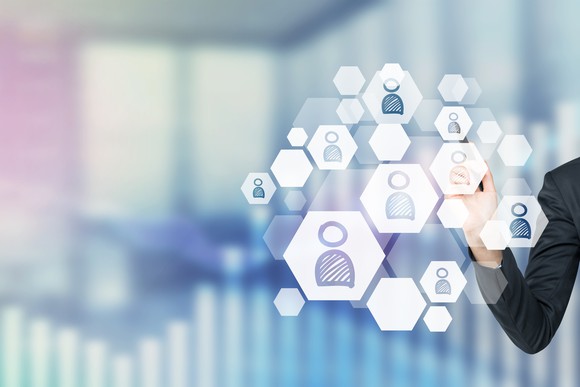 A businessman accesses a cloud of user profiles.