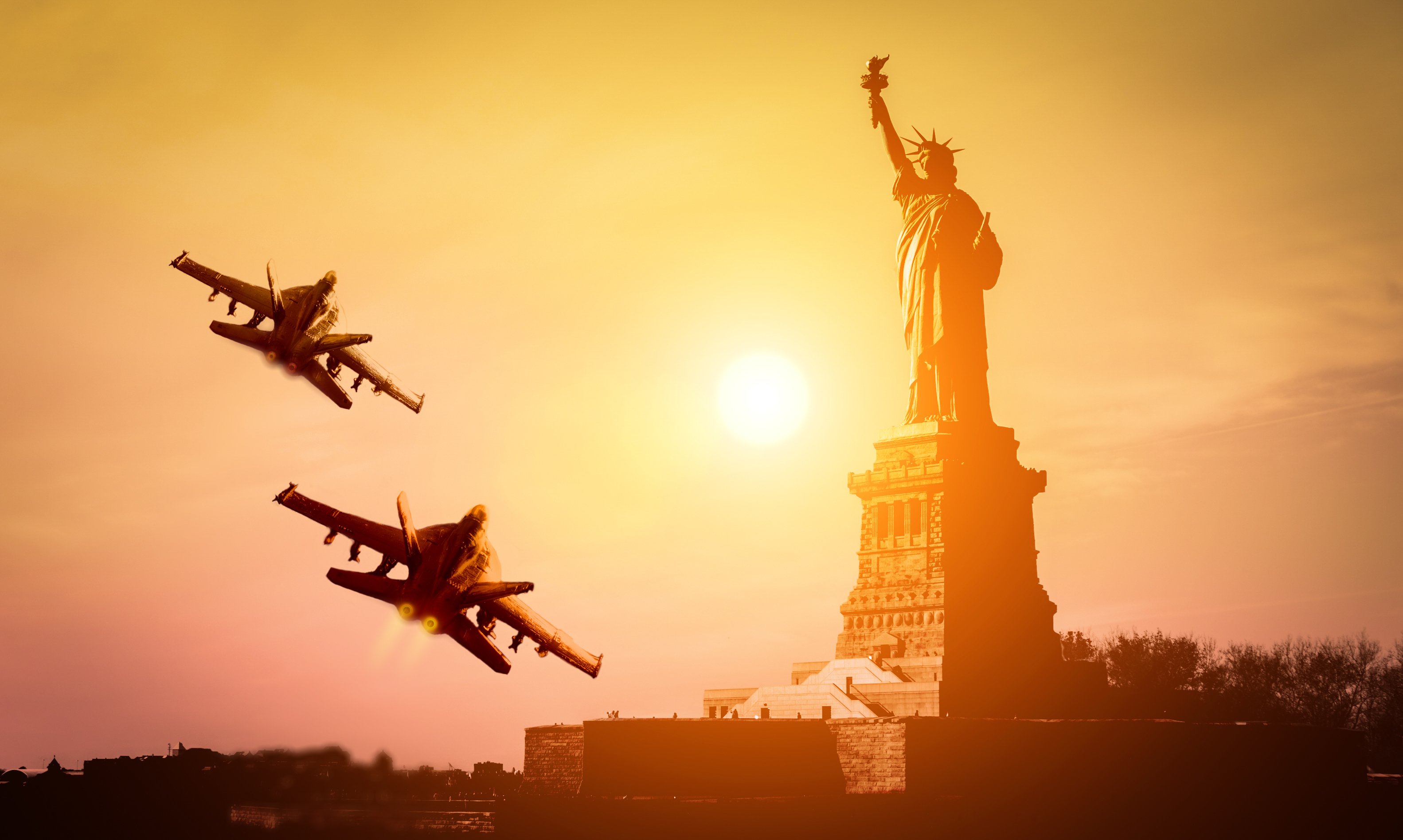 Two fighter jets flying with the Statue of Liberty in the background.