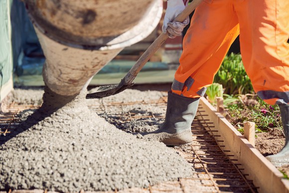 Worker spreading concrete.