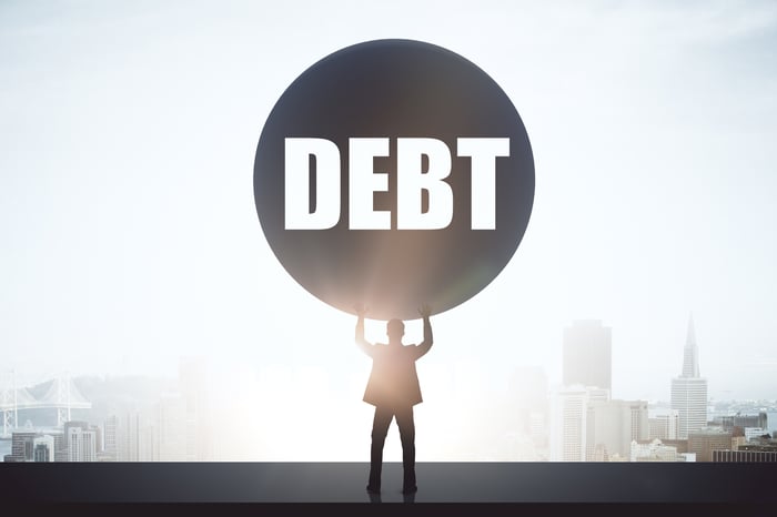 Person holding up a ball of debt