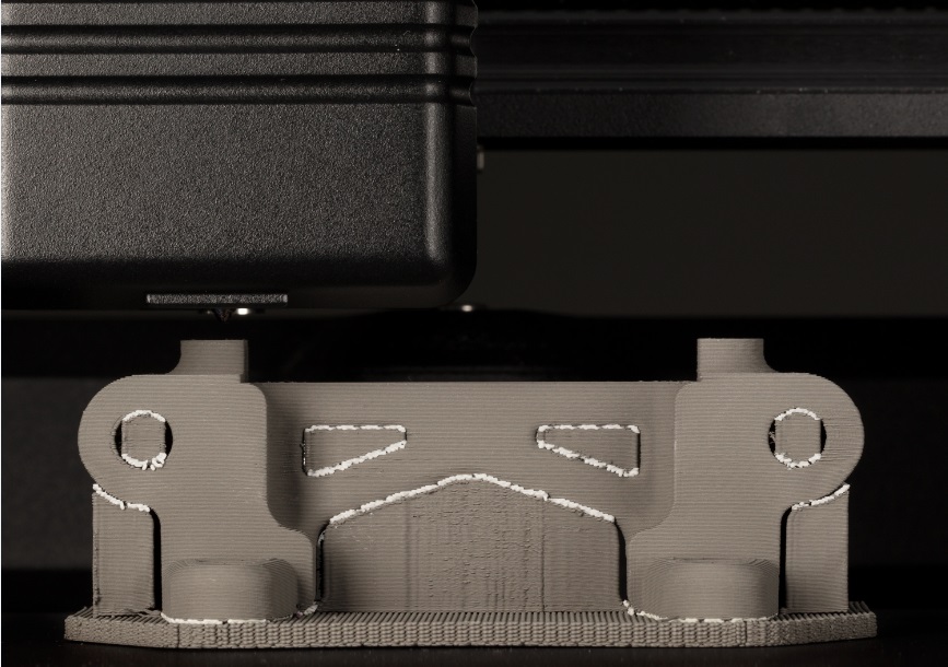 Close-up of a Desktop Metal 3D printer printing a metal part.