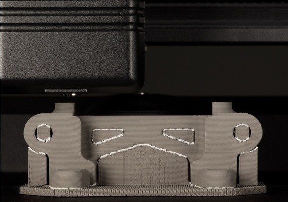 Close-up of a Desktop Metal 3D printer printing a metal part.
