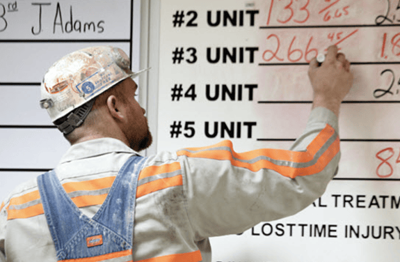 An Alliance Resource Partners employee writes down data on a whiteboard.