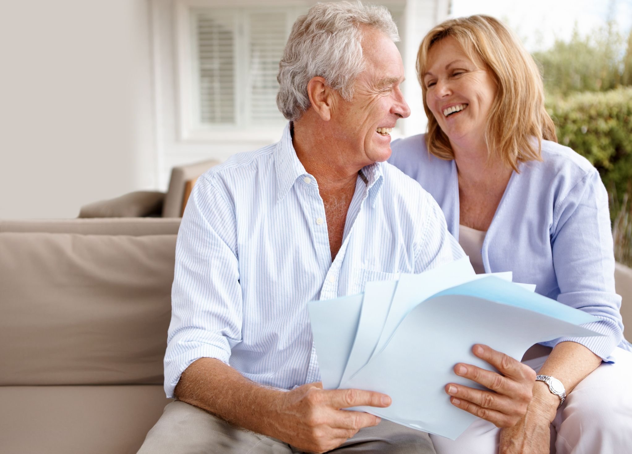 Mature couple smiling while reviewing papers