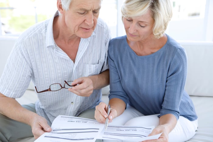 An older husband and wife going over paperwork.