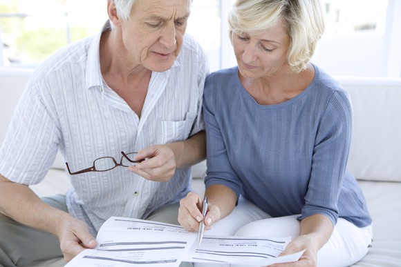 An older husband and wife going over paperwork.