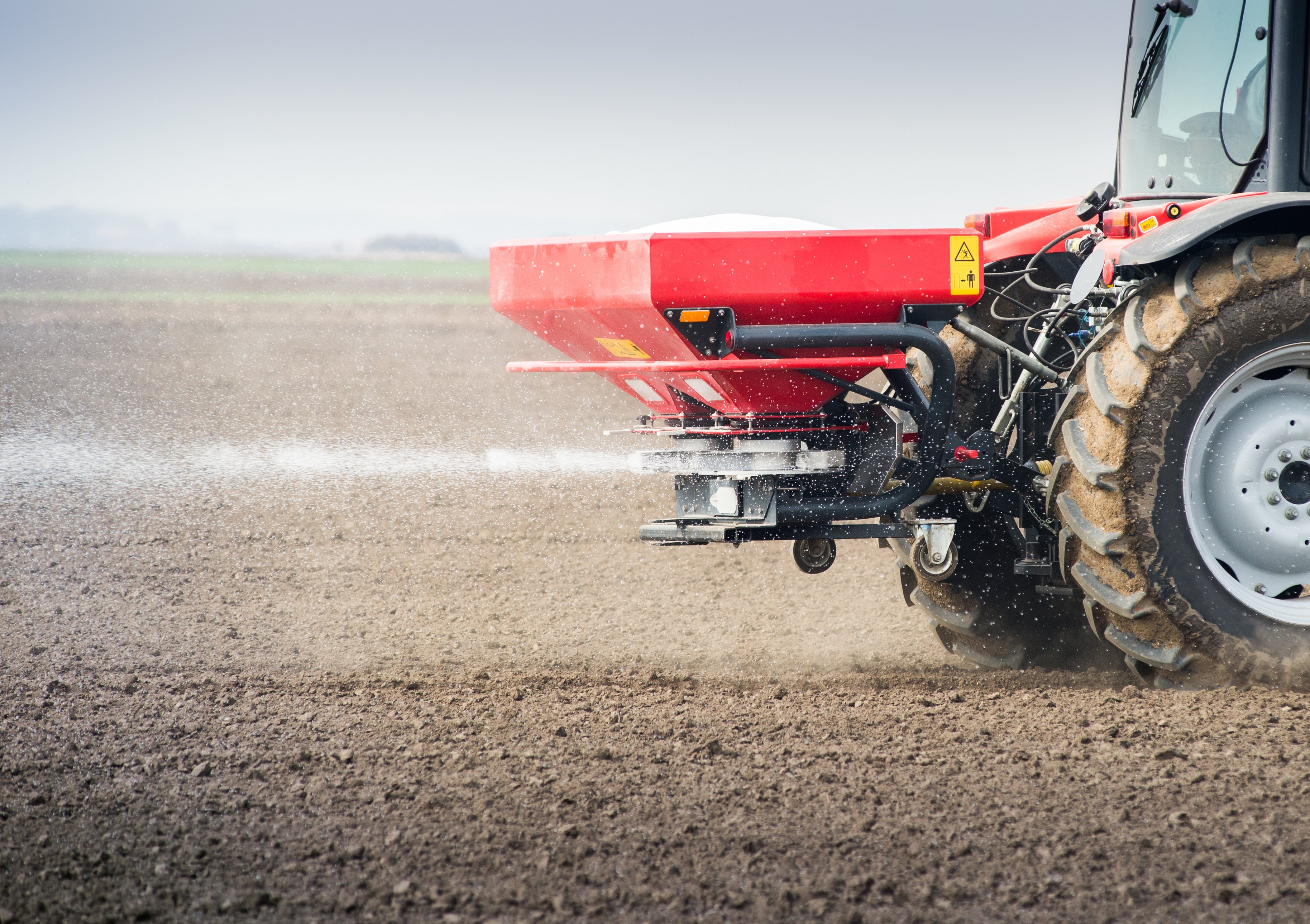 A tractor spreading fertilizer on a field.