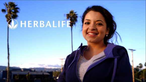 Woman on beach using Herbalife products.