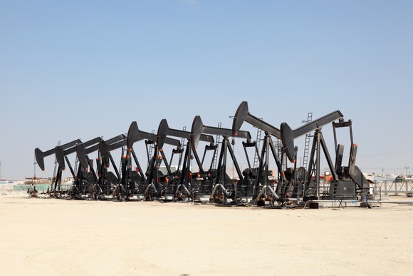 Black oil pump jacks in the desert.