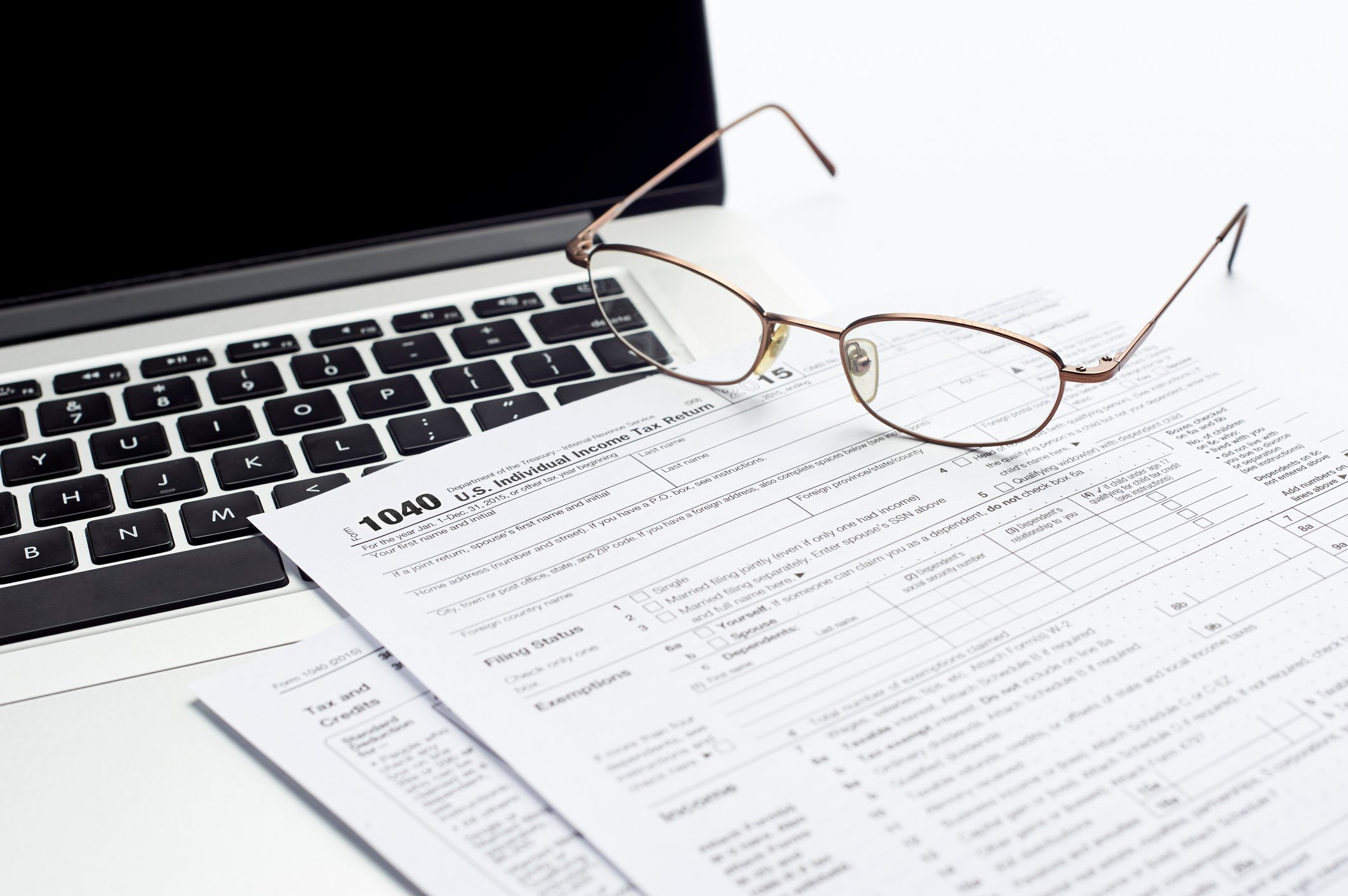 Tax documents by a laptop.