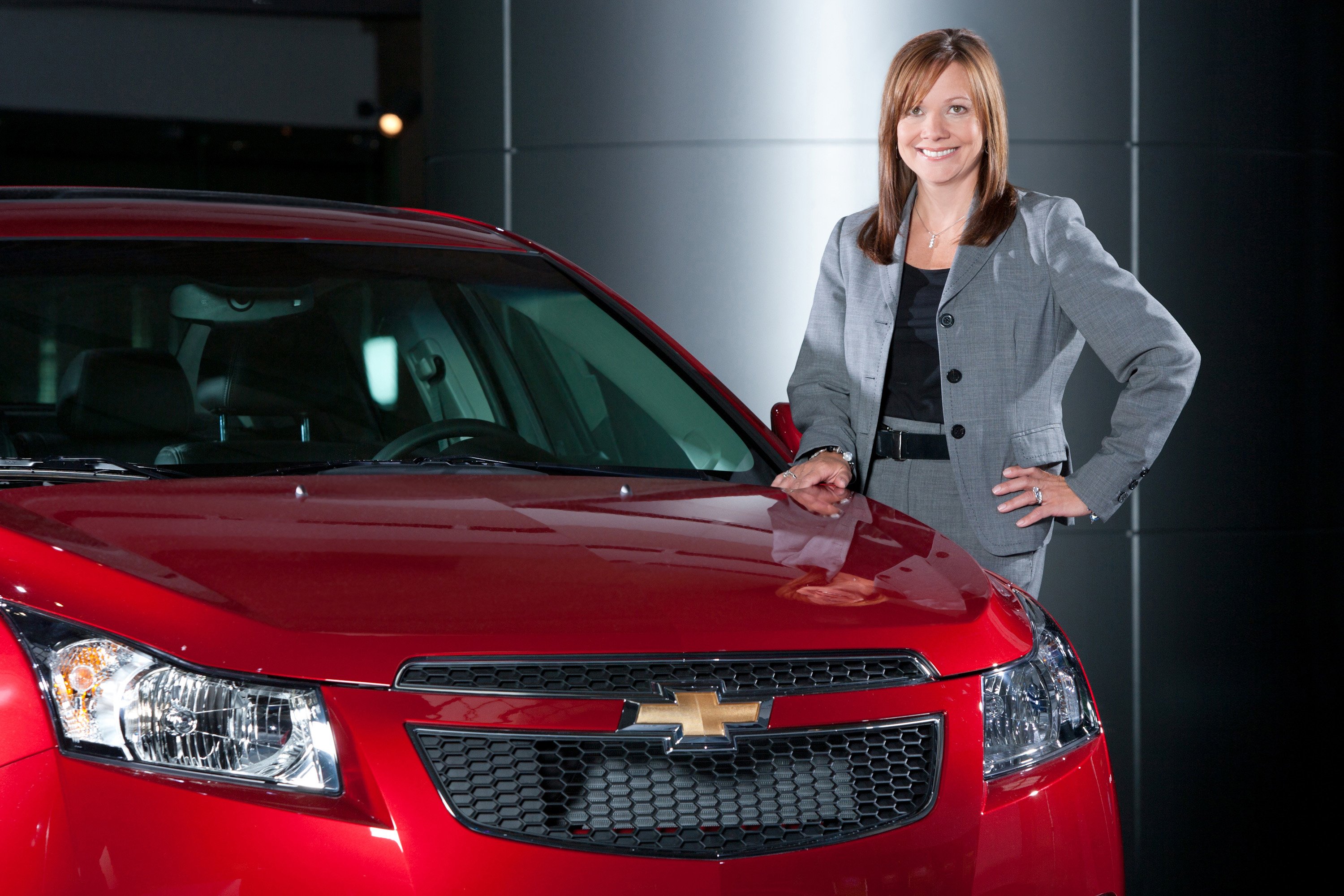 GM CEO Mary Barra next to a GM car.