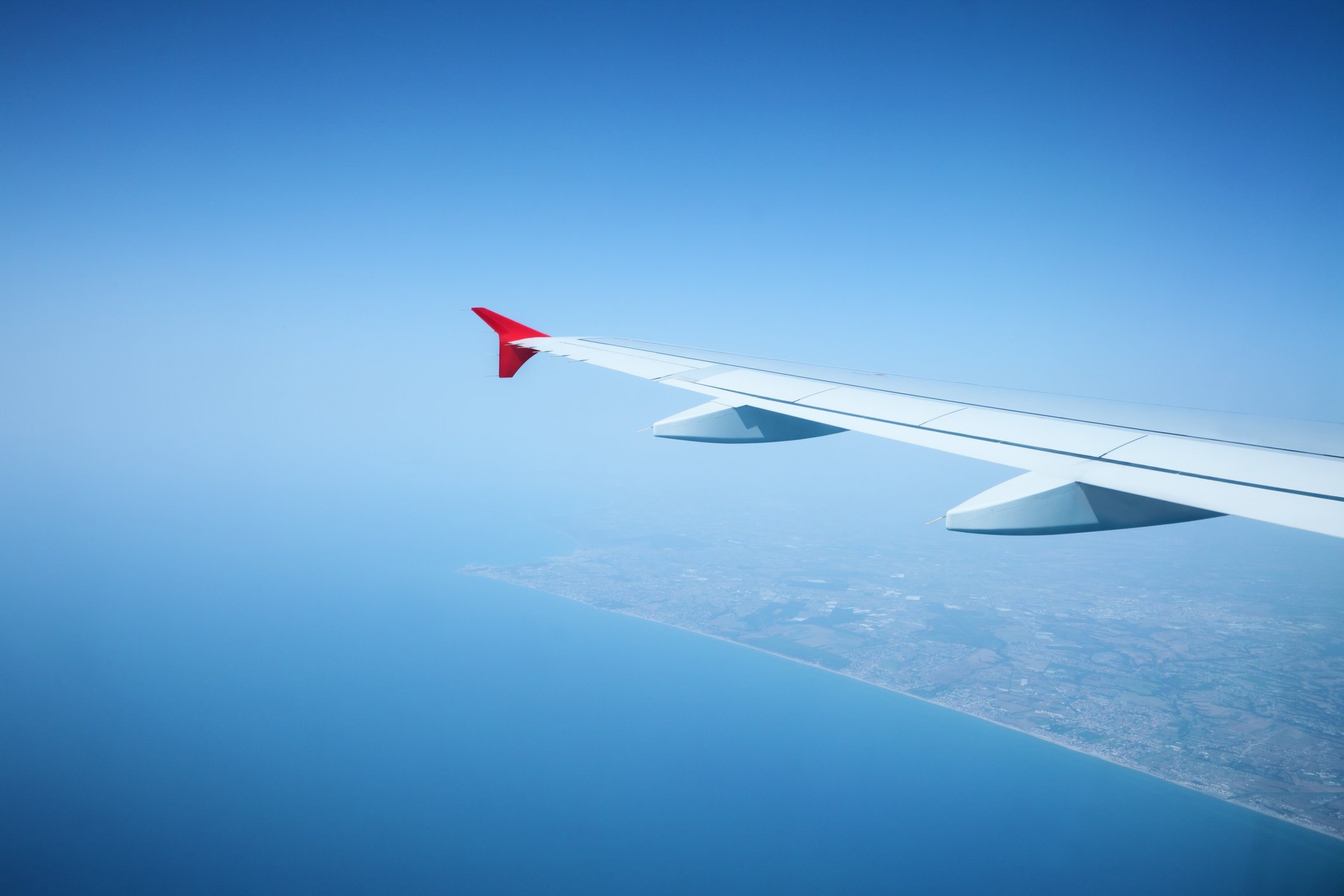 Airplane wing with sky in backdrop