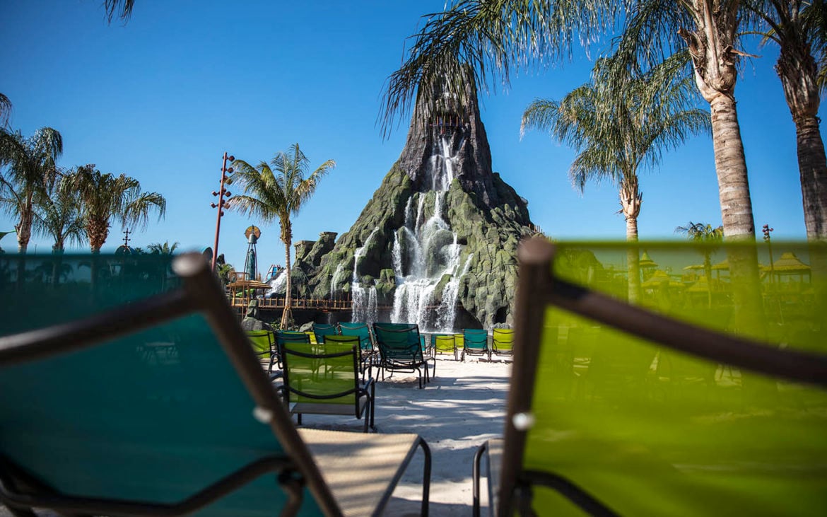 Beach shot of Volcano Bay's signature volcano with a waterfall trickling into the wave pool.