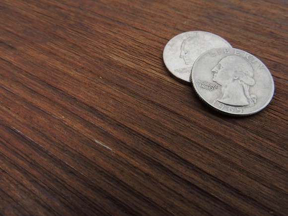 Two quarters sitting on a table.