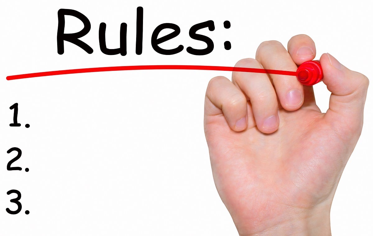 A hand writing "Rules" with "1" "2" and "3" written underneath.