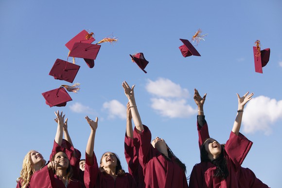 Students throwing caps in the air at graduation.